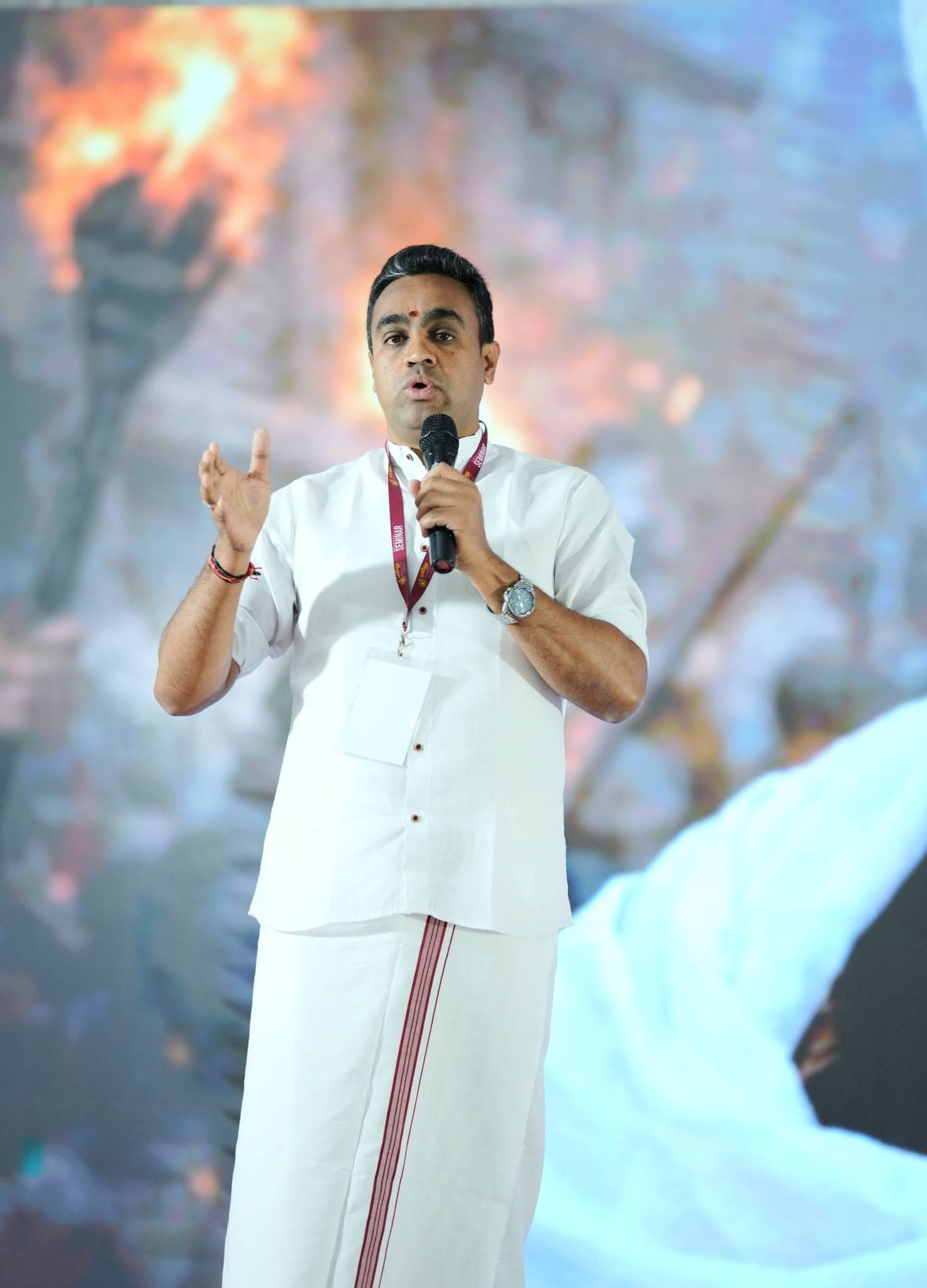 Manesh Chandran speaking in traditional dress